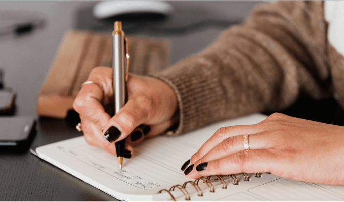 Person writing on a notebook
